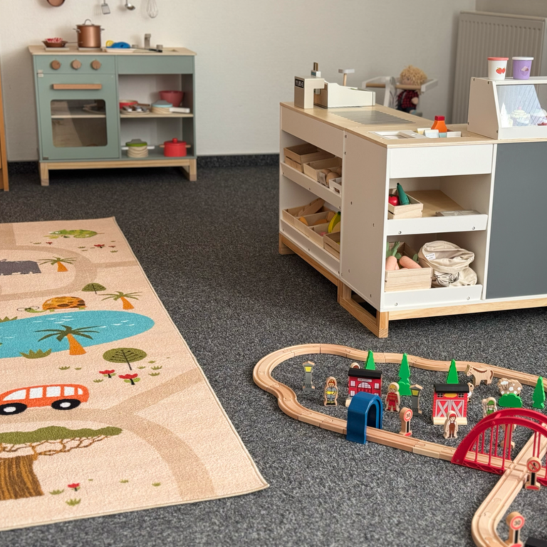 Holztisch mit Kasse und Spiellebensmittelauslage für Kinder.