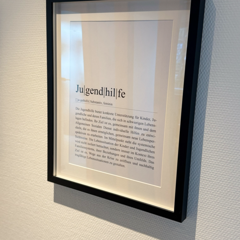Ein gerahmter Text mit dem Wort "Jugendhilfe" in großen Buchstaben an einer Wand.