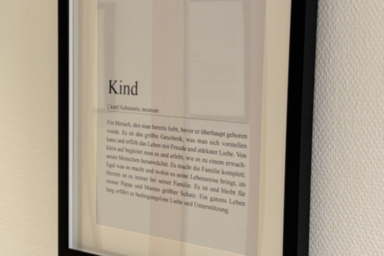 Ein eingerahmter Text über das Thema "Kind" an einer Wand.